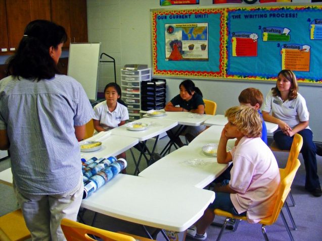 students sit around a table in a classroom