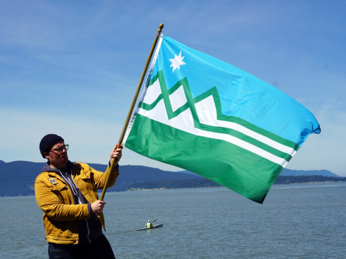 man waving a green and blue flag