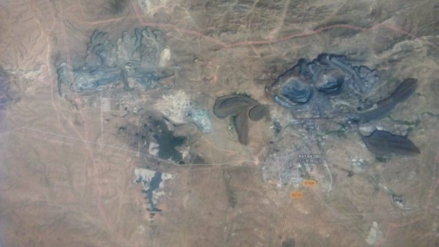 satellite image of dark craters in a brown landscape