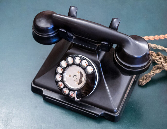 Photo of a vintage black "plastic" telephone with rotary dial.