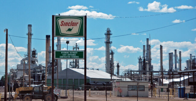 Photo of a refinery facility beneath a blue sky.