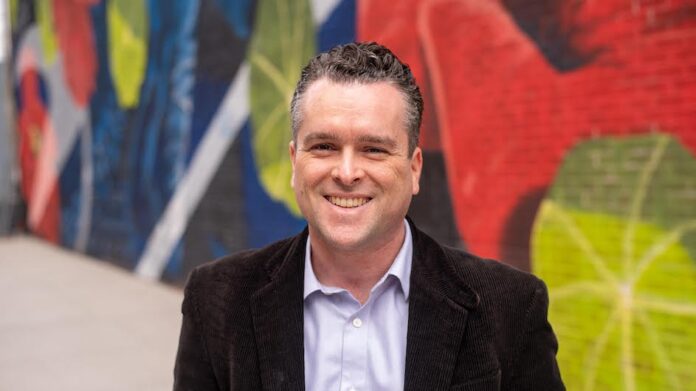Headshot of a man in front of bright walls
