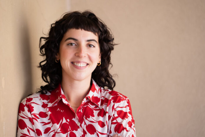 Headshot of woman in red and white top
