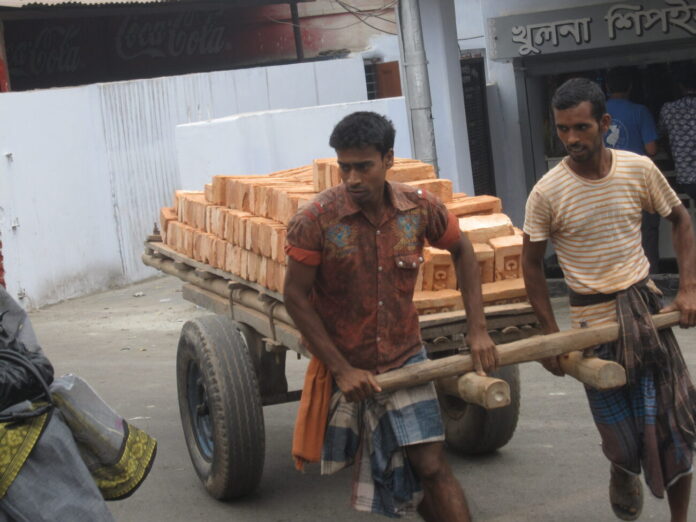 Men pulling cartful of bricks