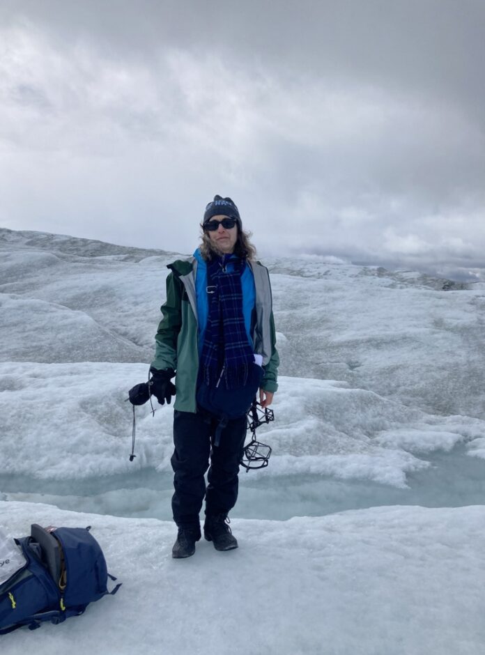 Woman in winter gear stands on glacier